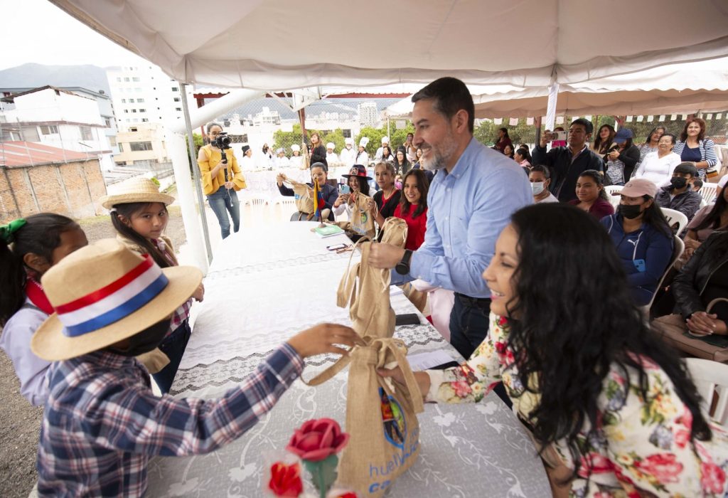 Deyber Jiménez, Gerente de Proyectos BUPA Ecuador recibiendo la Cosecha de las manos de los alumnos de la Unidad Educativa Fiscal 24 de Mayo de Quito. (Foto Cortesía)